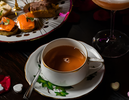 A fancy tea scene with a stacked dessert platter, assorted pastries, and a frothy cocktail on the side, perfect for a luxurious afternoon treat.