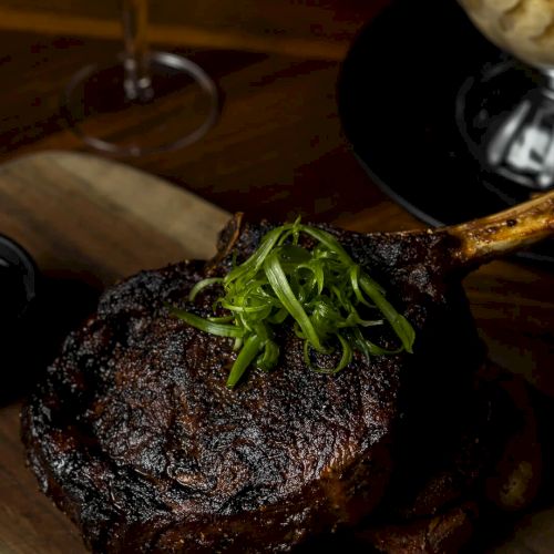 A close-up of a plate with a seared, purple-tare steak and greens, plus a glossy sauce and warm, rustic lighting. Ending this sentence.
